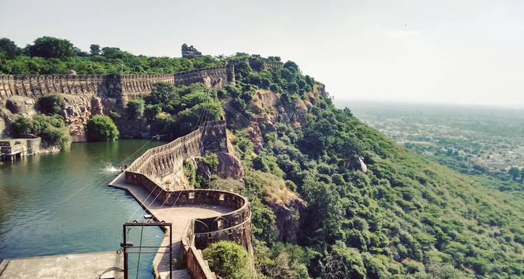 Un fort pittoresque surplombant un réservoir d'eau avec une ville au loin.
