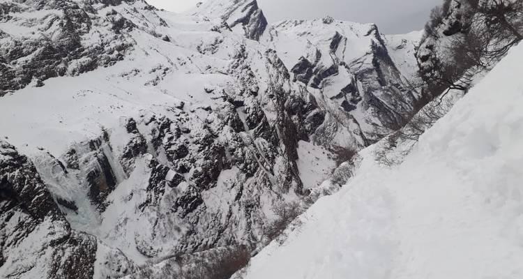 Schneebedeckte Berge mit bewölktem Himmel.