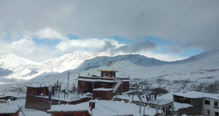 Schneebedecktes Dorf mit Bergen im Hintergrund.