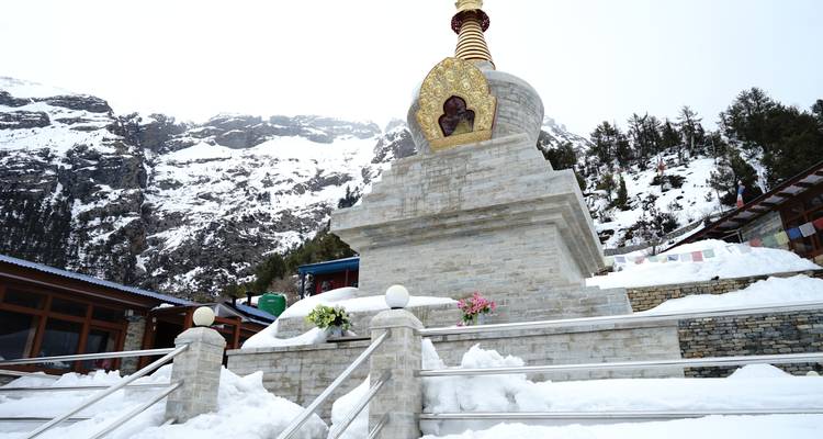 Chorten in a snowy landscape with tourists