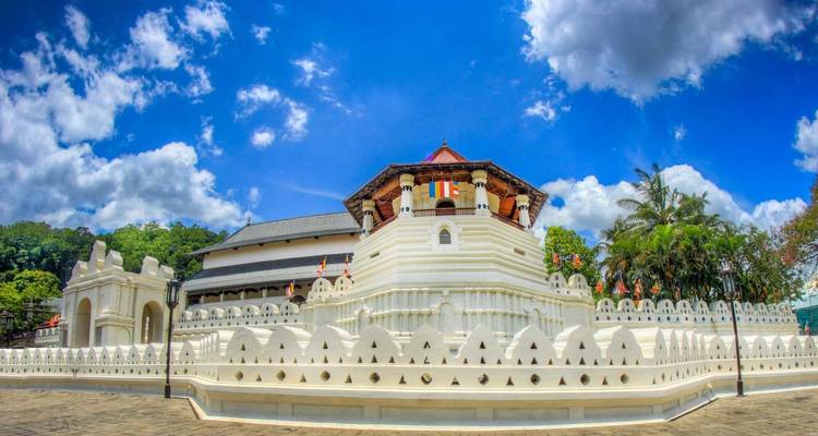 Templo con paredes decorativas blancas bajo un cielo azul despejado.