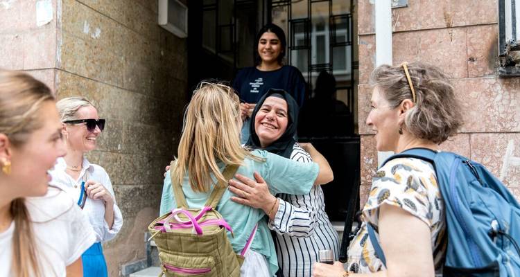 Turistas saludando a los lugareños con abrazos cálidos en un entorno callejero.