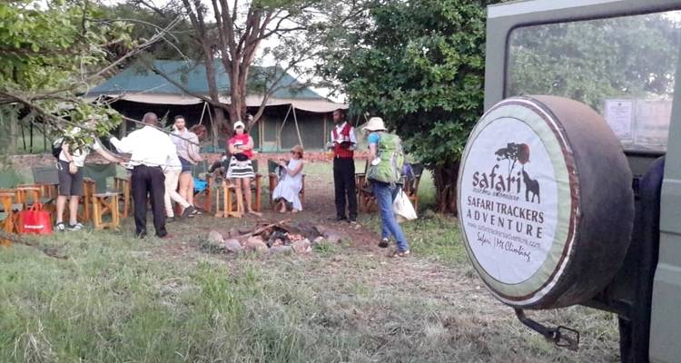 Groep mensen die genieten van een kampopstelling met safari-uitrusting.