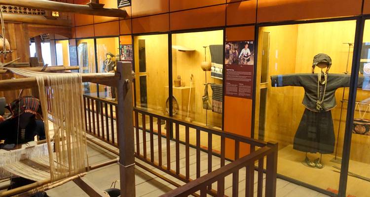 Museumsausstellung mit traditioneller Kleidung und Artefakten.