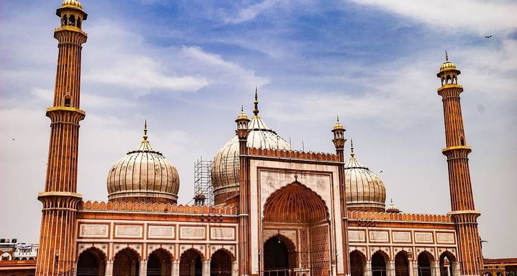 Mezquita histórica con tres cúpulas y minarete.
