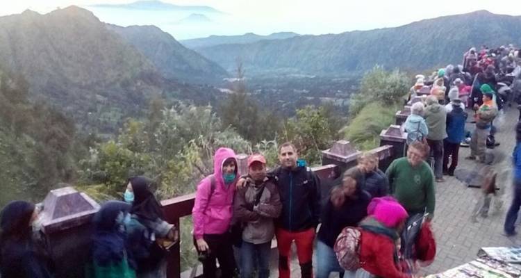 Een menigte mensen die uitkijkt over een bergdal.