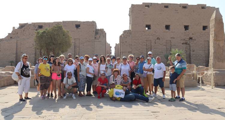 Gruppe von Touristen, die vor antiken Ruinen stehen.