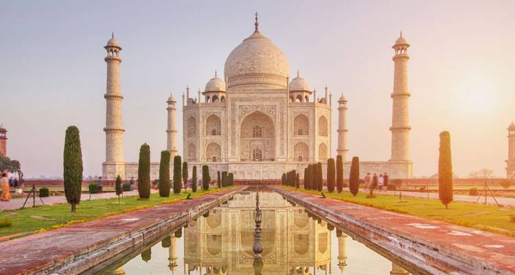 The Taj Mahal with its reflection in the foreground pool at sunrise.