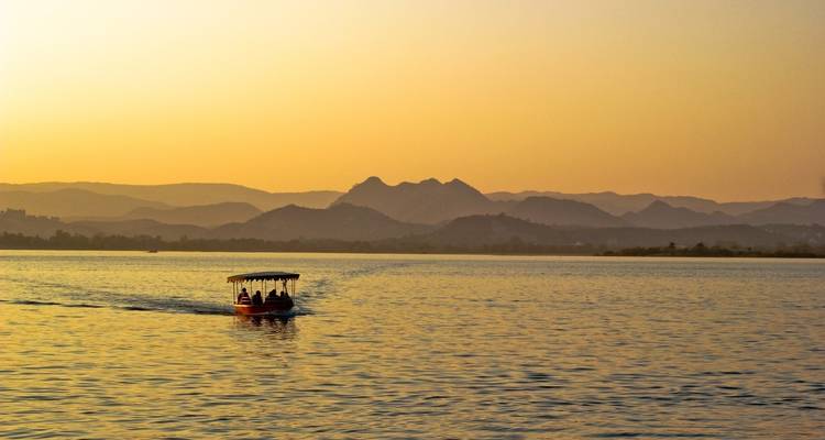 A boat ride on a lake during sunset with distant hills.