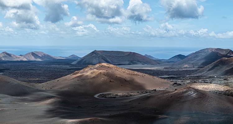 Paisaje volcánico con montañas escarpadas bajo un cielo nublado.
