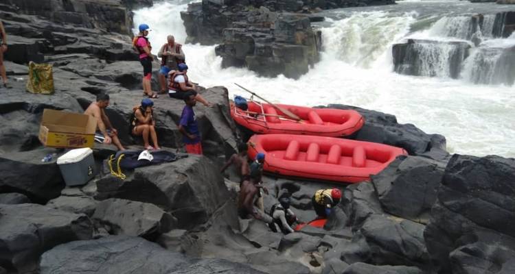 Eine Gruppe von Menschen, die sich bei den Felsen mit Flößen in der Nähe entspannen.