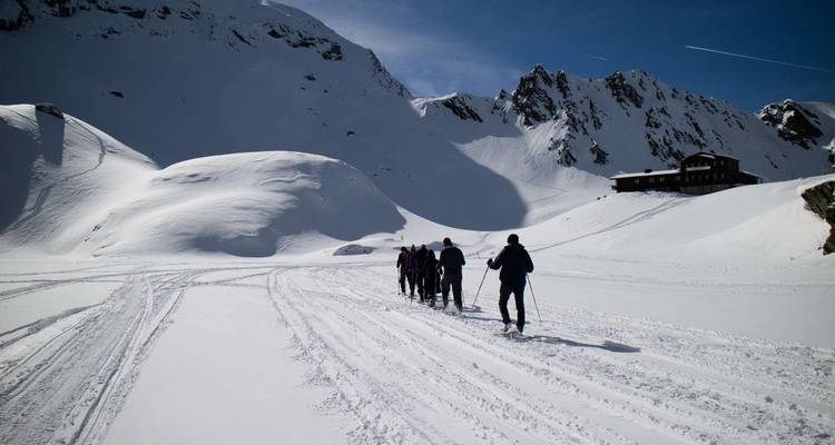 Group of skiers traversing a snowy mountain landscape.