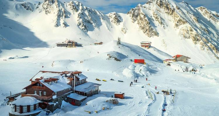 Ski resort with snowy mountains and people skiing.