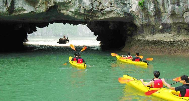 Kayakers paddling into a limestone cave.