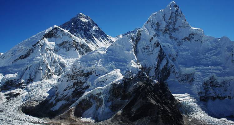 Primer plano de montañas cubiertas de nieve bajo un cielo despejado.