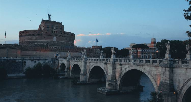 Vista del Castel Sant'Angelo y el puente en Roma durante el atardecer.