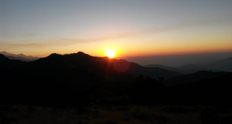 Een silhouet van bergen bij zonsondergang.