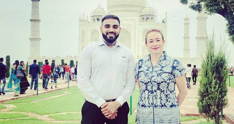 Deux personnes posant avec le Taj Mahal en arrière-plan.