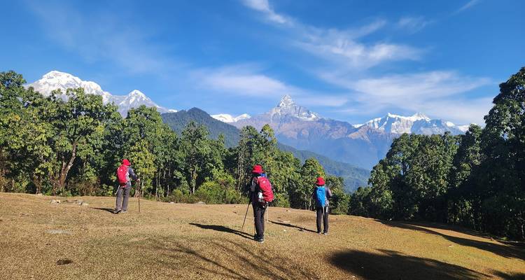 Excursionistas en primer plano con una cordillera en el fondo.