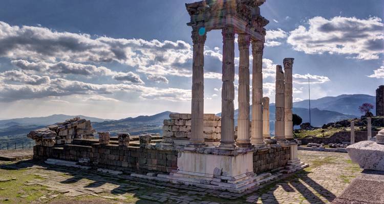 Antike Ruinen mit hohen Säulen und malerischem Himmelshintergrund.