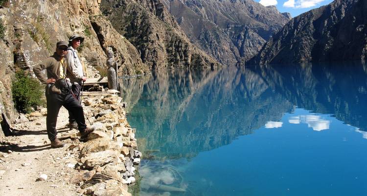 Wanderer, die entlang eines Sees mit Bergblick gehen