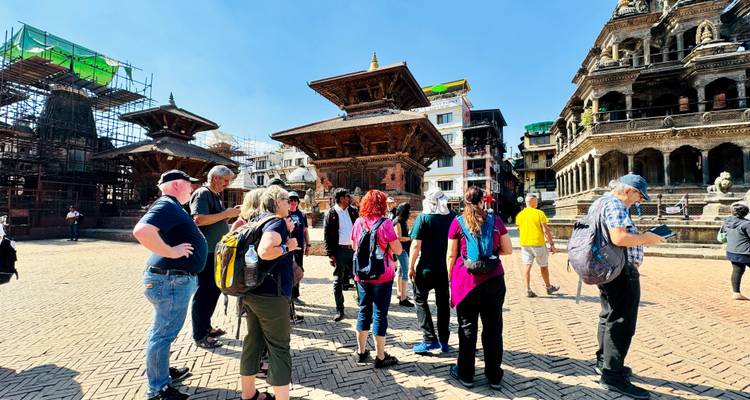 Des touristes sur un site culturel avec une architecture traditionnelle complexe.