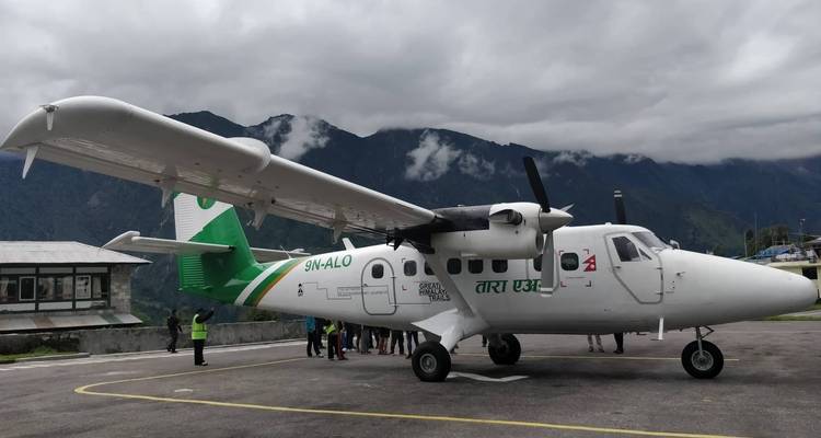 Flugzeug geparkt auf einem Flughafen bei bewölktem Himmel.