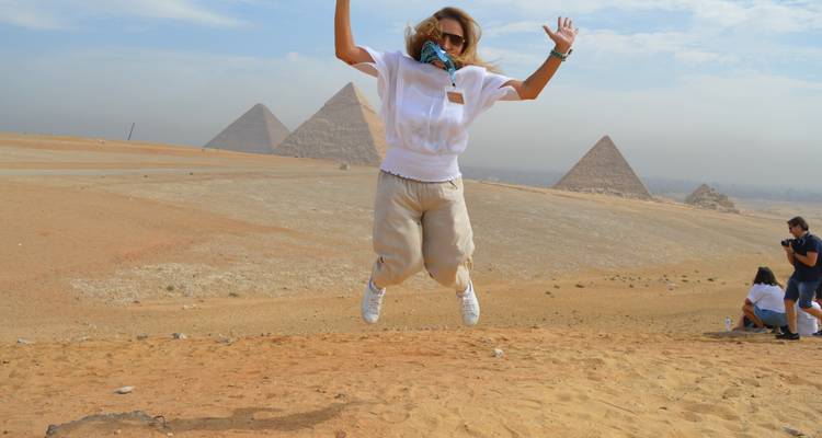 Person, die mit Pyramiden im Hintergrund springt.