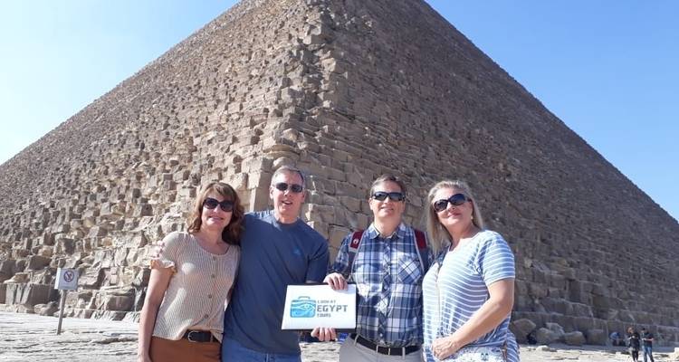 Gruppe von Touristen mit einer Pyramide im Hintergrund.