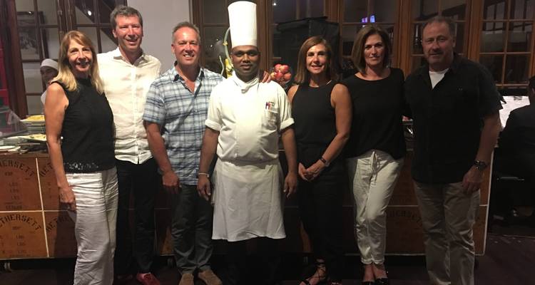 Groep mensen poseert met een chef-kok in een restaurant.