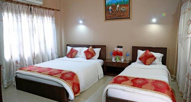 Chambre d'hôtel avec deux lits et décoration rouge.