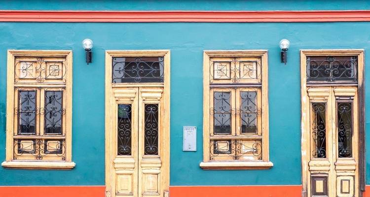 Fachada colorida de un edificio tradicional con ventanas y puertas ornamentadas.