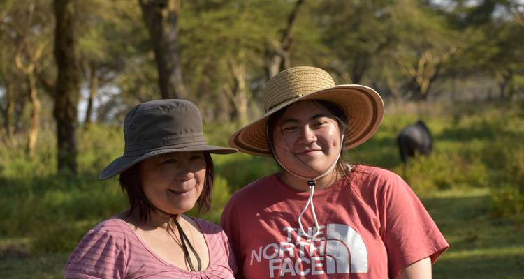 Two people smiling wearing hats outdoors.