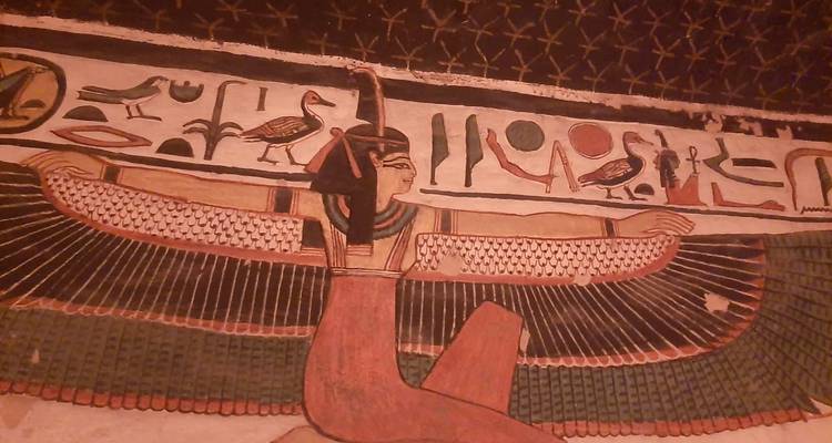 Egyptian wall art depicting a winged goddess and hieroglyphs.
