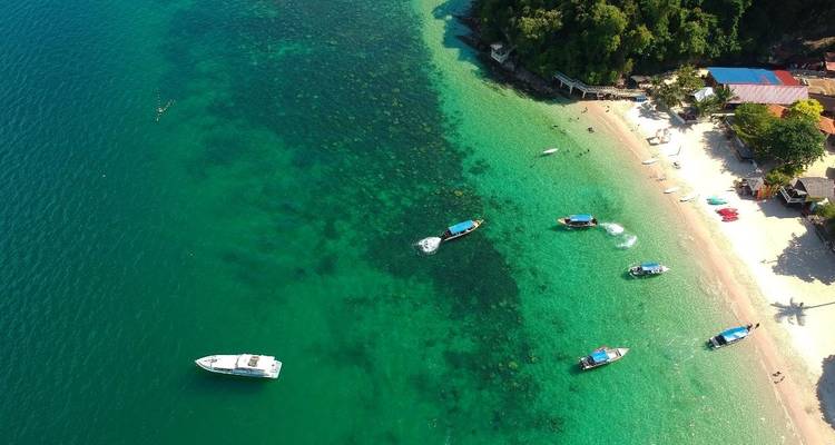 Vue aérienne d'une plage animée avec des bateaux sur l'eau.