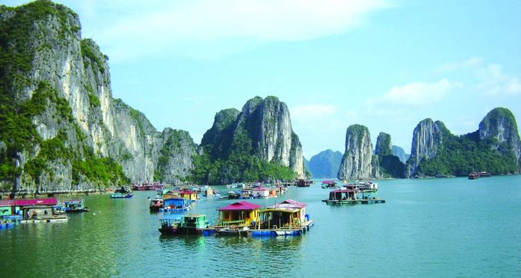 Colorful floating structures in Halong Bay with limestone karsts.