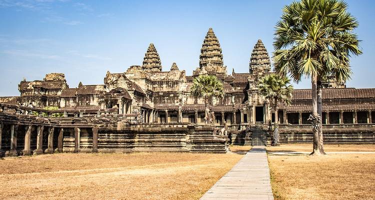 Vue large d'Angkor Vat avec des palmiers.
