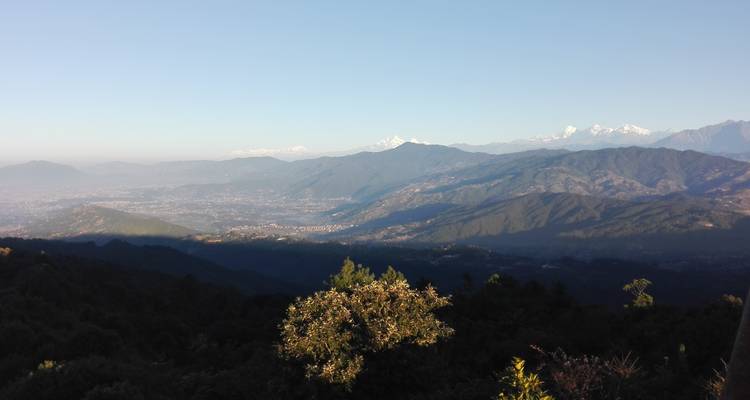 Uitgestrekt uitzicht op glooiende heuvels en verre bergen.