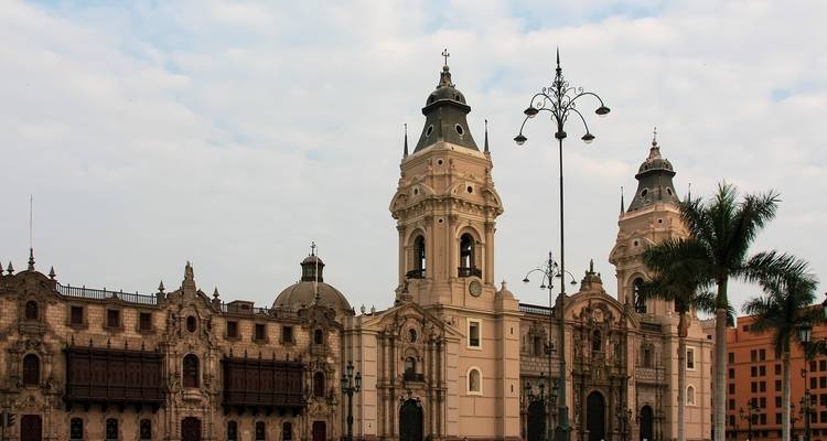 Un gran edificio colonial con palmeras en Lima.