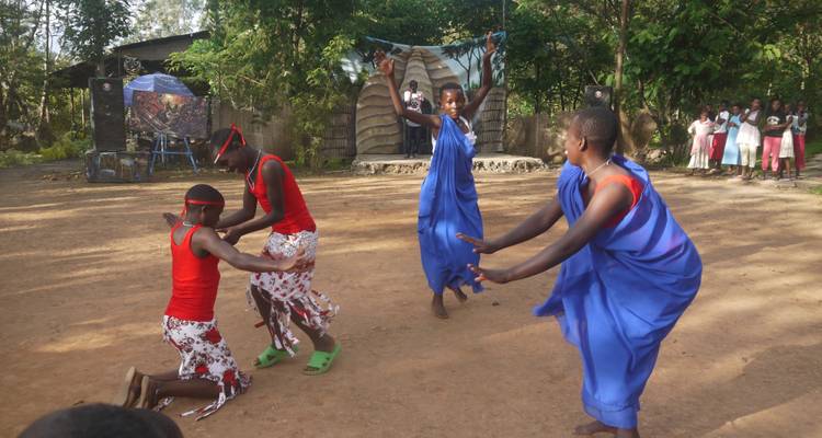 Gruppe von Menschen in traditioneller Kleidung, die einen Tanz aufführen.
