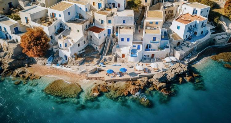 Vue aérienne d'un village côtier grec avec des maisons blanches au bord de la mer.