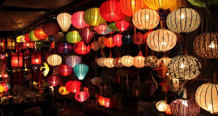 Faroles coloridos exhibidos en un mercado nocturno.