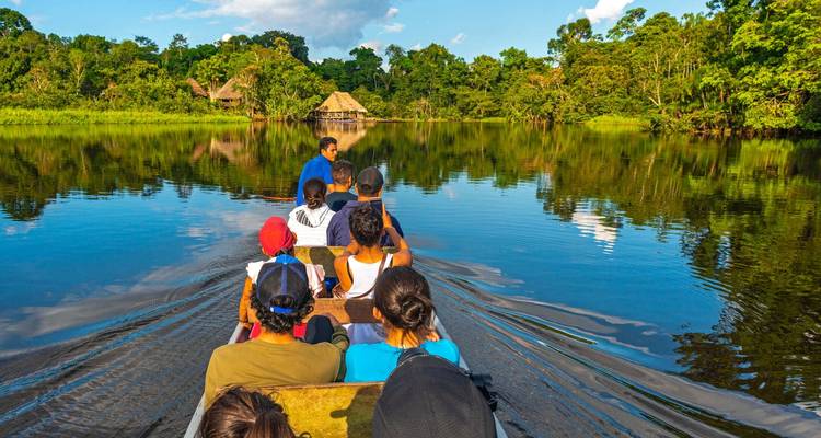 Menschen bei einer Bootstour in einem üppig bewaldeten Gebiet