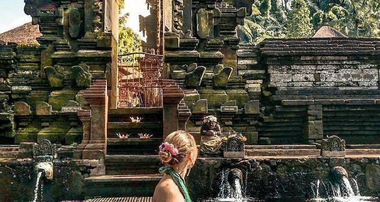 Personne se tenant près d'un temple ancien avec des éléments d'eau.
