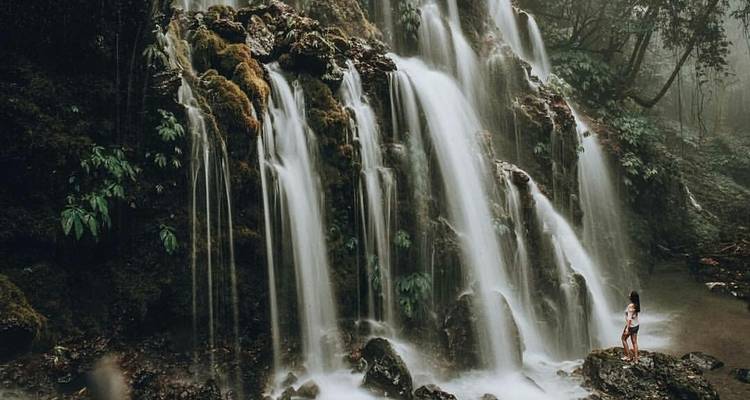 Personne debout devant une grande cascade.