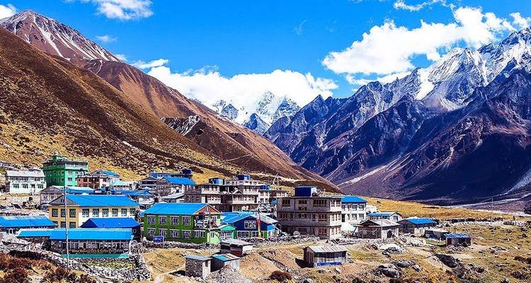 Schilderachtig bergdorp met levendige blauwe daken en besneeuwde bergen.