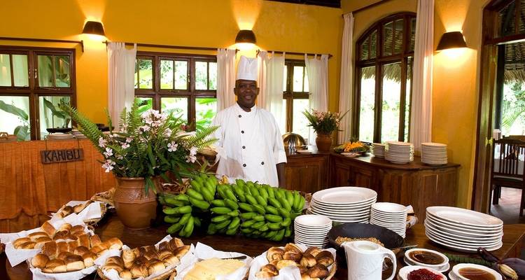 Montaje de buffet en un comedor rústico con chef listo para servir.