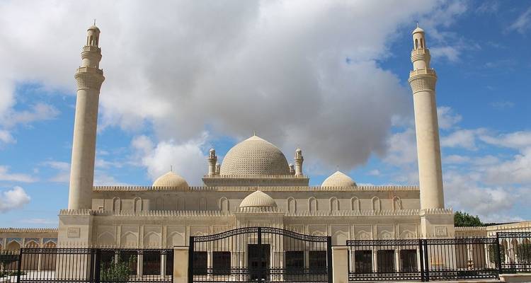 Una mezquita con cúpulas y minaretes contra un cielo nublado.