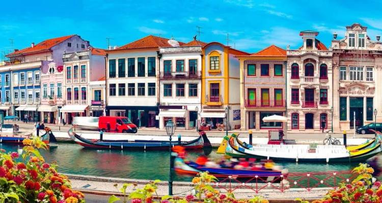 Levendige gevelrijen langs het kanaal en traditionele moliceiro-bootjes geven kleur en charme aan de Portugese stad Aveiro.