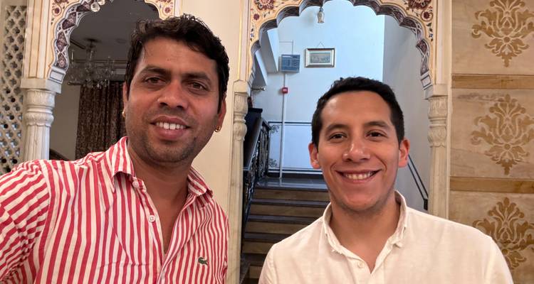 Zwei Personen posieren drinnen mit kunstvollen Dekorationen.